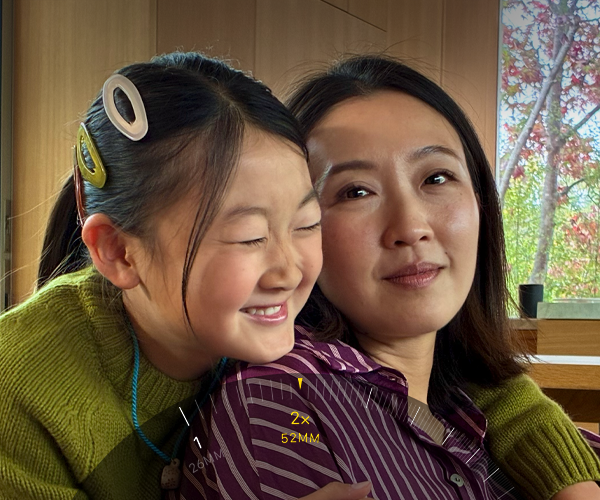 2倍望遠機能を使って、抱き合う2人の人物にズームインしている