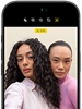 ブラックのiPhone 18 Pro、前面の外観。カメラに向かってポーズをとる2人のモデルが表示され、センターフレームフロントカメラの機能を示している