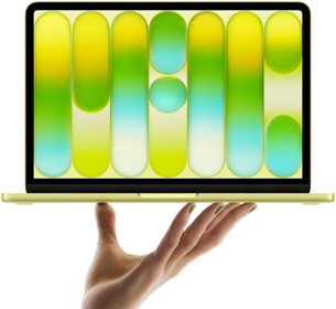 開いた手の指先がシトラスのMacBook Neoをバランス良く支えている。画面にはカラフルで抽象的なパターンが表示されている